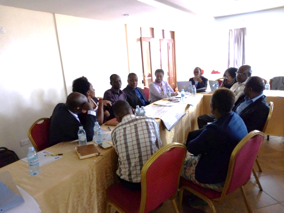 Dr Suzanne Kiwanuka of MakSPH ( 2nd left), Mr Tonny Odokonyero of EPRC ( 3rd left) and Ms Robinah Kaitiritimba of UNHCO ( 5th on the left table) participating in the group work.