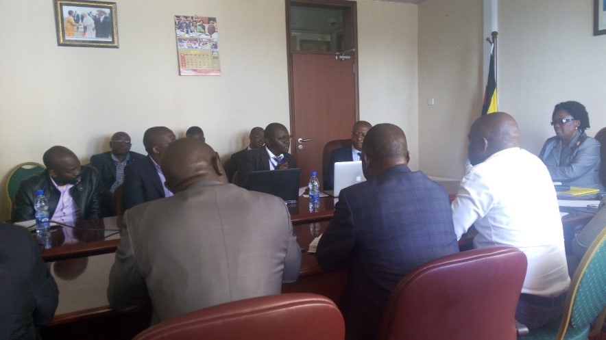 Dr. Jimmy Opigo( with a black laptop) presenting about different chemicals used in mosquito nets and IRS noting efforts by Makerere School of Public health under SPEED to generate evidence on cheaper IRS models.