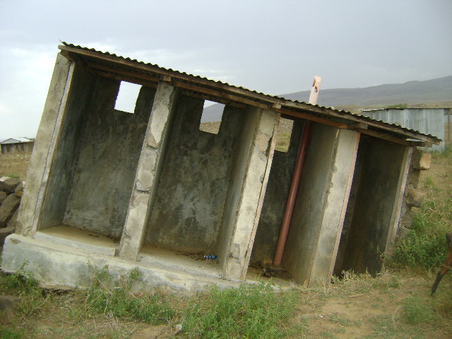 Collapsed pit latrine block around Narok, Kenya, where unlined pit latrines easily collapse in the sandy and instable soil after heavy rainfalls