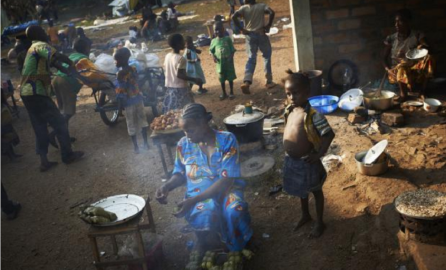 Mom cooks manioc parcels to sell while her daughter Florent stands by... UNHCR 