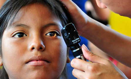 Doctor examines a patient's eyes in Paita, Peru