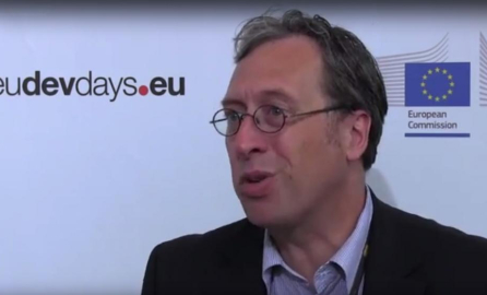 Photo of the male interviewee with glasses and the Capacity4dev logo on the background