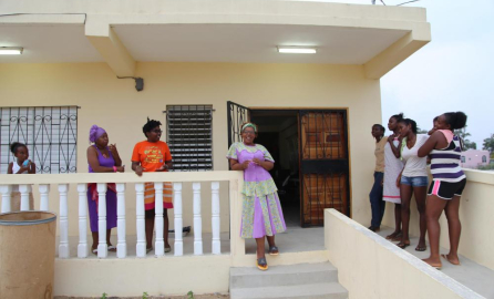 Michele Irving surrounded by powa sisters outside the powa house in Belize decorative image