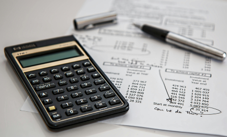 A calculator, a sheet and a pen to indicate symbols of "budget"