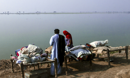 A Pakistani family sets up camp by flooded lands