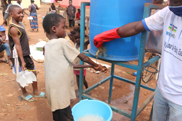 Un enfant se lave les main dans une station de lavage des mains su site de SEGA - © G. Bogangabe / UNICEF