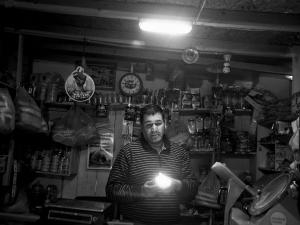 Santiago, Chile. Aug. 2013. A shopkeeper lit by led lightbulbs in the Lo Espejo district of Santiago.(Photo Moises Saman/MAGNUM)