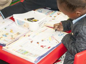 A school child in Tembisa using one of the text books