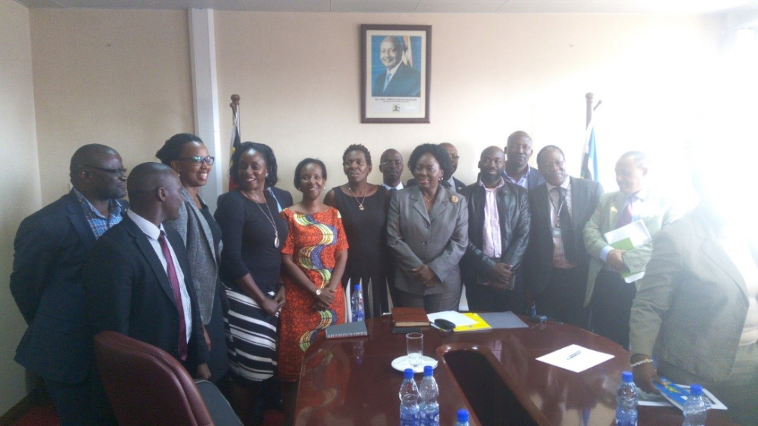 SPEED Director, Prof. Freddie Ssengooba (third person on the left, with a tag), Dr. Aloysius Ssennyonjo behind the speaker and Mr. Richard Ssempala (in a red tie) and other stakeholders posing fora group photo with the speaker.