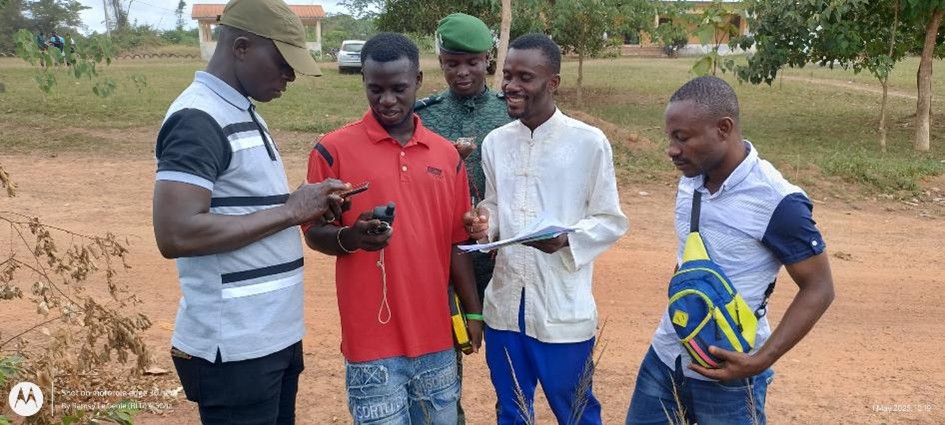 Five men standing together looking at their handheld devices used for ecological monitoring