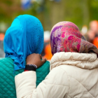 Two refugee women wearing a colourful scarf