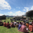 People sitting on grass at a community meeting