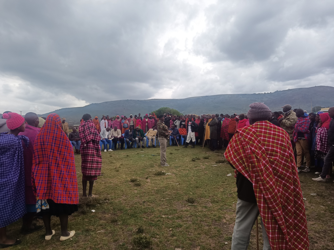People standing on grass at community meeting